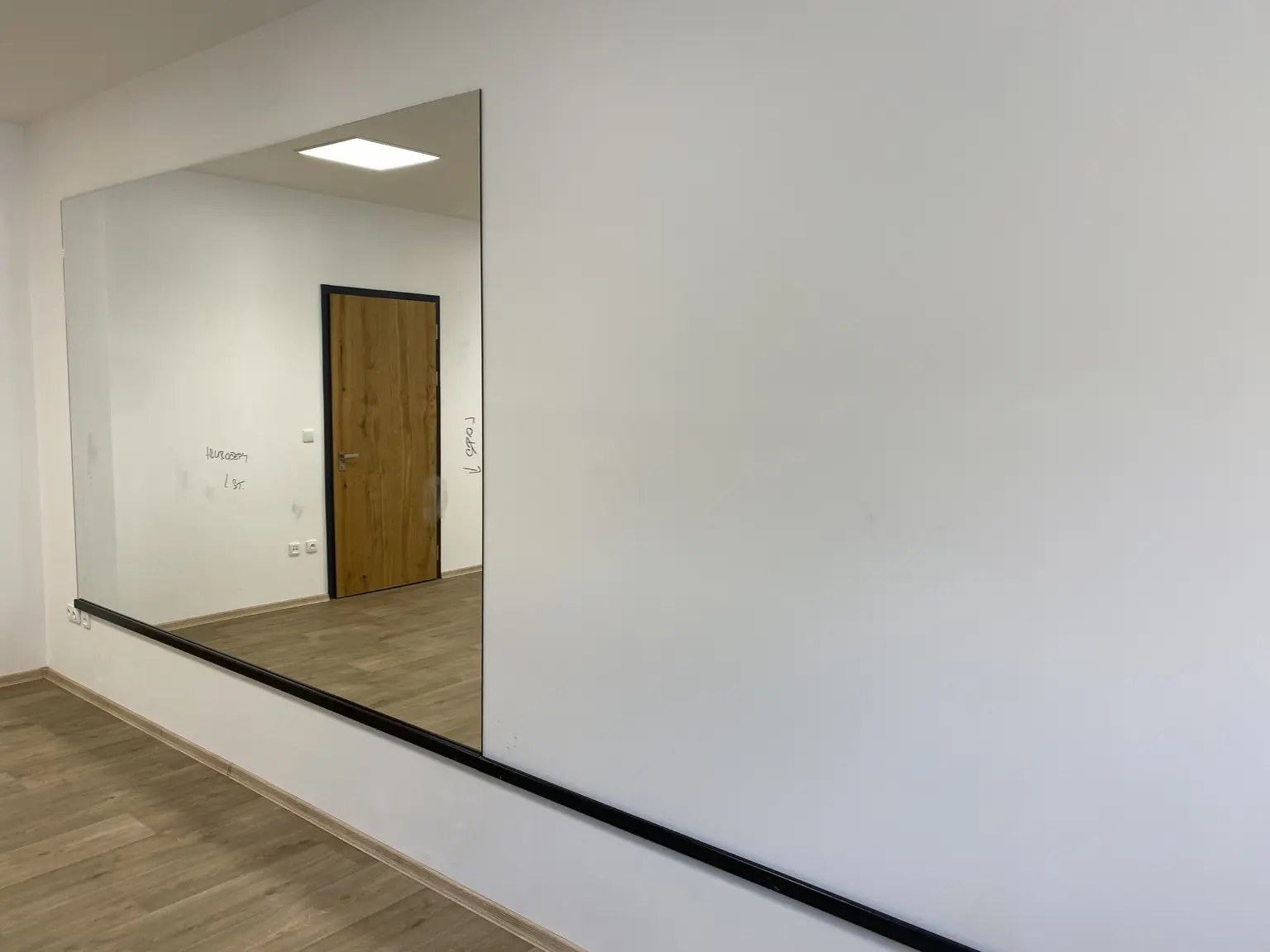 Samostatný velký zrcadlový panel na černé ochranné liště